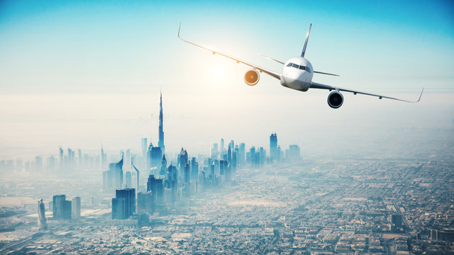 Fototapeta Commercial airplane flying over modern city
