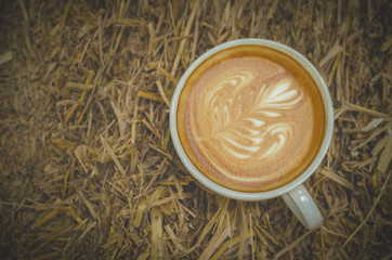 Top view of coffee cup on hay background
