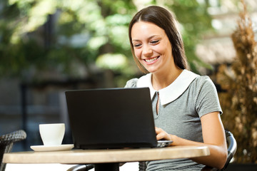 Young woman is using laptop in a cafe.