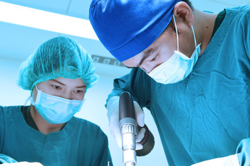 two veterinarian surgeons in operating room take with art lighting and blue filter