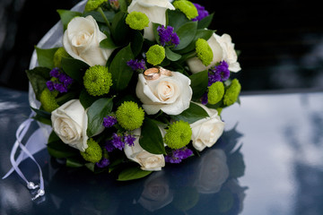 Wedding bouquet lies on the car. Wedding day.