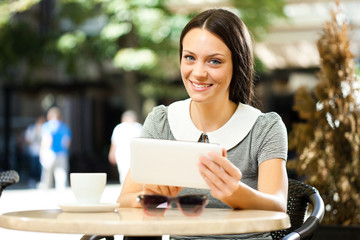 Young woman is using digital tablet in a cafe.