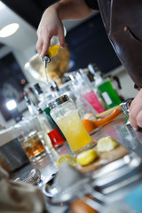 Fototapeta na wymiar Bartender is straining cocktail in a glass
