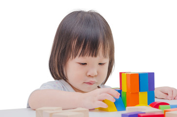 Little Asian girl playing colorful wood blocks