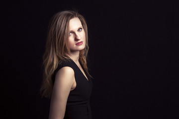 Naklejka premium beautiful young blonde posing over dark background