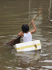 The girl paddle the foam boat when flooding