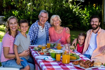 Happy multi-generation family enjoying breakfast in yard 