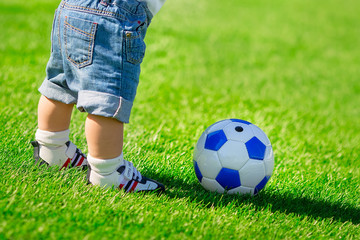 boy with a soccer ball on green grass