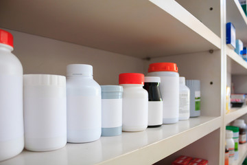 medicine bottles arranged on shelf at drugstore