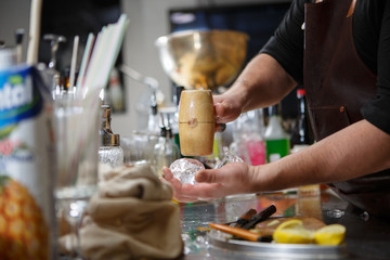 Obraz na płótnie Canvas Bartender pours alcoholic drink into small glasses with flames