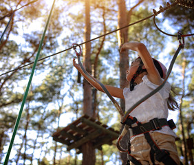 The girl in a helmet on a rope park