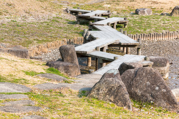 wooden bridge zigzagging on dry pond with drought.