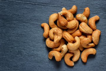 Roasted cashew nuts on dark stone background