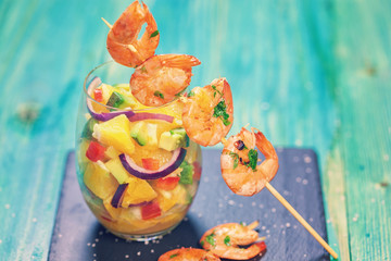 Grilled shrimps on skewers with salad 