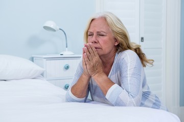 Woman praying in bedroom