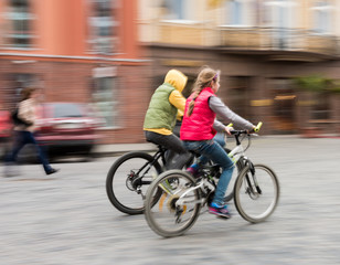 Fototapeta na wymiar Children riding bicycles on a city street
