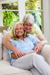 Obraz premium Happy senior couple sitting on sofa in living room at home