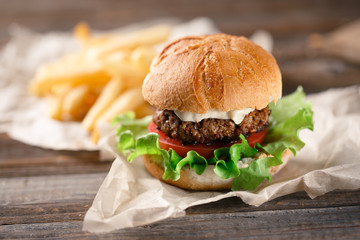 Homemade burger with french fries on wooden table