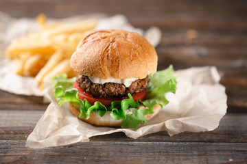Homemade burger with french fries on wooden table