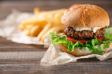 Homemade burger with french fries on wooden table