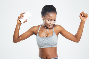 African sportswoman with mobile phone listening to music and dancing