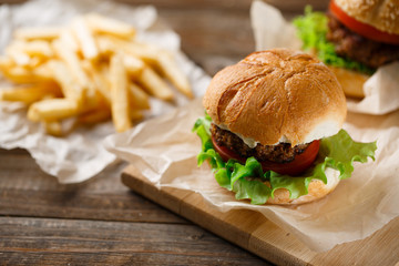 Homemade hamburgers and french fries on wooden table