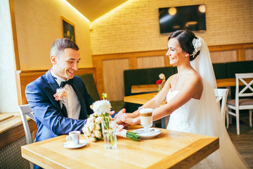 Just married couple embrace, wedding pair hugging, Bride and Groom, Romantic Married Couple in restaurant, holding hands, beautiful couple in the hotel , They Hug each other, wedding