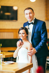 Just married couple embrace, wedding pair hugging, Bride and Groom, Romantic Married Couple in restaurant, holding hands, beautiful couple in the hotel , They Hug each other, wedding