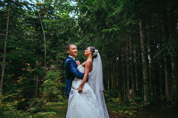 newlyweds in park.newlyweds on walk in the beautiful wood.newlyweds embrace.embraces of newlyweds.newlyweds in the spring wood.gentle.relations.feelings.beautiful groom and bride.fantastic wedding.