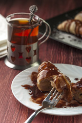 Fresh cut puff with chocolate glaze on plate with fork