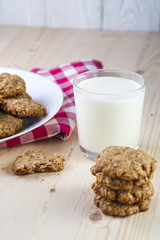 Glass of milk and oatmeal cookies on table