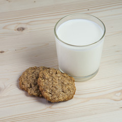 Two oatmeal cookies with milk glass