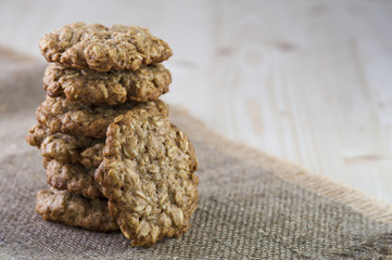 Tasty oatmeal cookies on burlap napkin