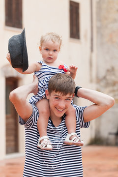 Portrait Of Cheerful And Happy Big Brother And Little Sister, Outdoor, Italy.