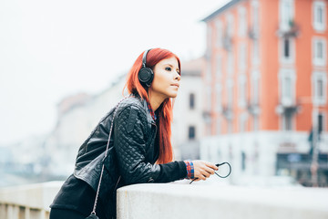 Knee figure of young beautiful hispanic redhead woman listening