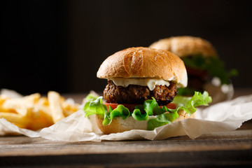 Homemade tasty burger and french fries on wooden table