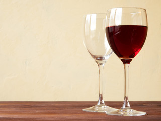 Glass of red wine on the wooden table. Side view