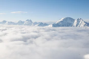 Foto op Canvas Keten van bergen die uit de wolken steken © k1777