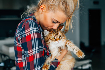 Beautiful young girl holging her ginger cat. Bestfriends.