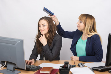 Office worker stealthily going to hit on the head with a colleague notebook
