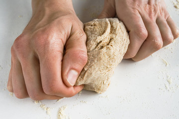 Woman's hands kneading wholegrain dough.