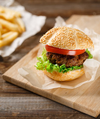 Homemade hamburgers and french fries on wooden table