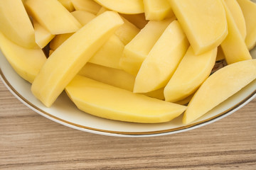Raw sliced potatoes in a plate.