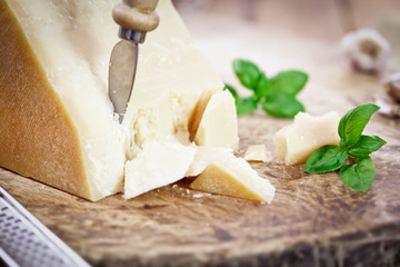 Parmesan Cheese with Basil Leaves on wooden board © circleps
