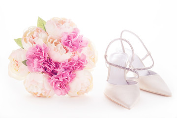 Beautiful wedding shoes and bouquet isolated on white. 
