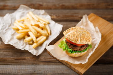 Homemade hamburgers and french fries on wooden table