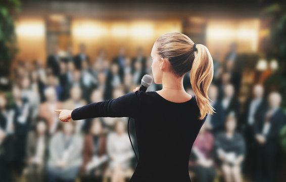 Donna su palco parla microfono