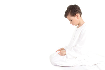 Muslim young boy praying moving his finger up and down during tashahud
