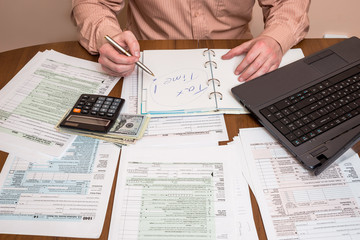 Obraz premium Filling 1040 tax form wtih laptop