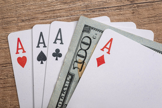 four poker aces with 100 dollar bills